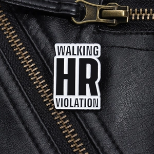 Macro detail of 'Walking HR Violation' enamel pin badge on a black leather jacket