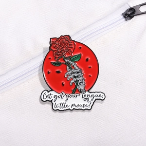 Red rose and skeleton hand enamel pin badge on white canvas bag accessory