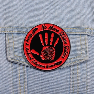 Détail du pin's émaillé No More Stolen Sisters sur une veste en jean bleu