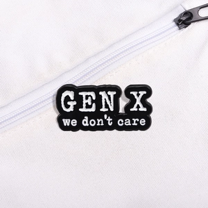 Close-up of Gen X We Don't Care enamel pin attached to a white canvas zipper bag