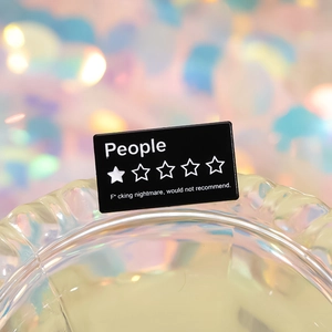 Broche en émail noir créative avec texte de critique une étoile et fond bokeh coloré