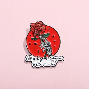 Gothic skull hand holding red rose enamel brooch with creative quote text on pink background
