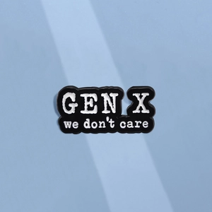 Minimalist black enamel Gen X We Don't Care slogan pin badge with wave-cut edges