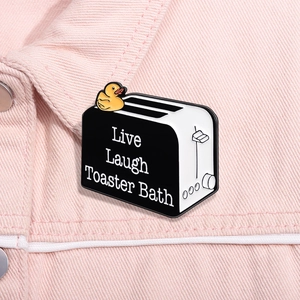Détail du pin's émaillé canard grille-pain avec texte Live Laugh Toaster Bath sur du denim