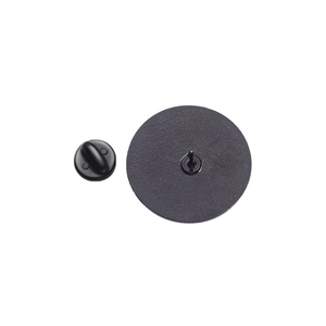 Macro view of matte black metal badge base and rubber pin back on white background