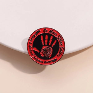 MMIW enamel pin featuring a red handprint and missing sisters advocacy message