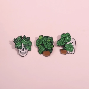 Detailed close-up of three punk style monstera pins with skull and ghost designs