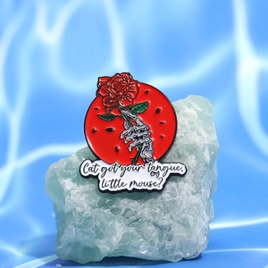 Skull hand and red rose enamel pin with red geometric background on green crystal