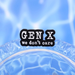 Minimalist black and white enamel pin featuring GEN X we don't care slogan on blue water