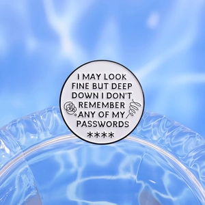 Round white enamel pin with I May Look Fine text design on clear blue water background