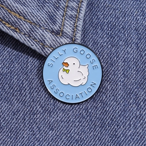 Macro shot of a Silly Goose Association enamel pin on dark blue denim fabric texture
