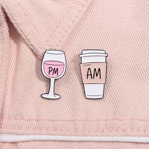Detail von AM und PM Emaille-Pins auf Jeansjacke mit kreativem Kaffee- und Weinglas-Design