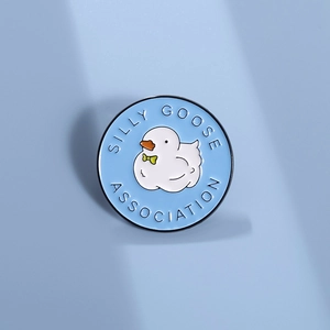 Detail view of the SILLY GOOSE ASSOCIATION enamel pin with a white duck motif