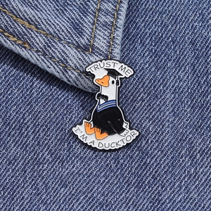 Detailed close-up of a cartoon Ducktor enamel pin on blue denim fabric background