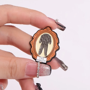Creative enamel brooch featuring a suit in a vintage orange frame with THE SWUIT text