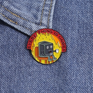 Funny enamel pin with Everything is Under Ctrl design on denim jacket background