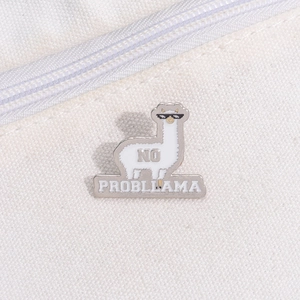 Detail shot of a funny alpaca enamel pin with pixel sunglasses on white canvas