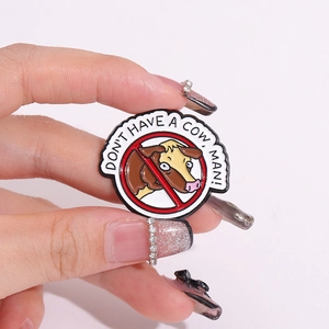 Round enamel pin featuring a funny cartoon cow and 'DON'T HAVE A COW, MAN!' slogan
