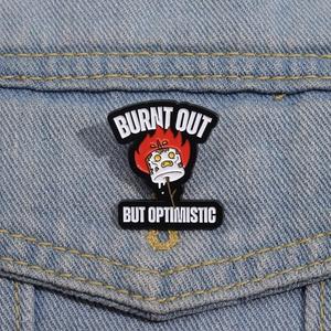 Macro shot of Burnt Out But Optimistic marshmallow enamel pin on blue denim jacket
