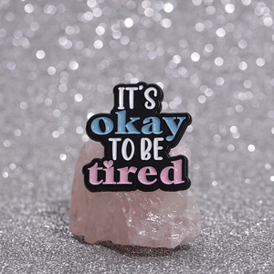 Emaille-Anstecknadel mit Spruch It's Okay to Be Tired auf rosa Kristallen