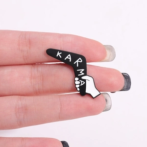 Broche boomerang karma en émail noir avec motif de main en alliage de zinc