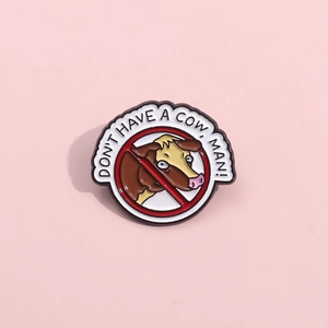 Detail of cartoon cow brooch with 'DON'T HAVE A COW, MAN!' text on pink background