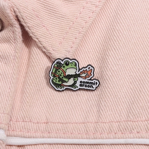 Détail de l'épingle émaillée grenouille avec lance-flammes sur tissu en jean rose