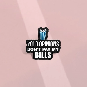 Détail du pin's émaillé avec la phrase Your Opinions Don't Pay My Bills dans la poubelle