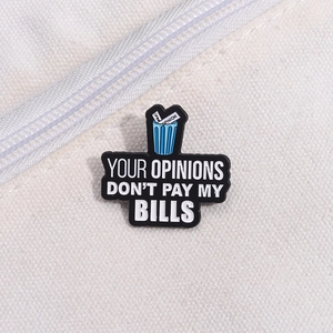 Détail du pin's émaillé sur un sac en toile avec citation Your Opinions Don't Pay My Bills