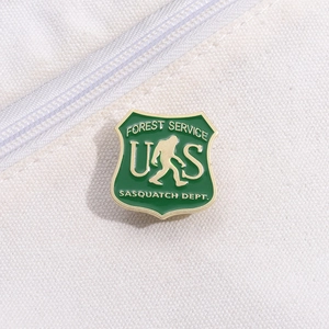 Macro detail of a green Forest Service Sasquatch shield badge on canvas fabric