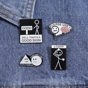 Kreatives Emaille-Anstecknadel-Set mit lustigen Sprüchen auf blauem Denim-Hintergrund