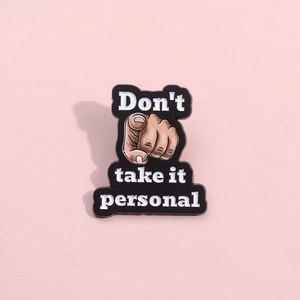Creative enamel pin badge featuring hand gesture and 'Don't take it personal' text