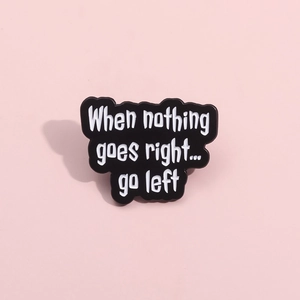 Black enamel badge featuring 'When nothing goes right go left' text on pink background