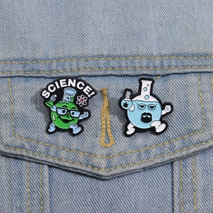 Detailed close-up of science theme enamel pins on denim jacket featuring flask characters