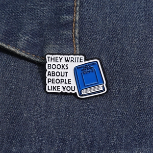 Detalle del pin esmaltado libro DSM-5 en tela vaquera con texto creativo para ropa y bolsos