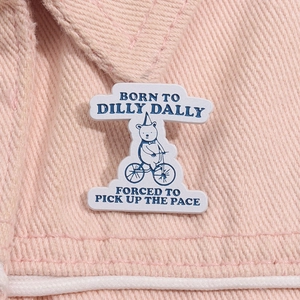 Close-up of a cartoon bear riding a bicycle pin on a pink denim jacket collar