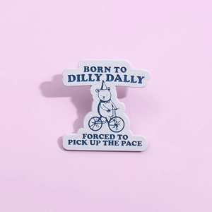 Cartoon bear riding a bicycle enamel pin with Born to Dilly Dally English slogans