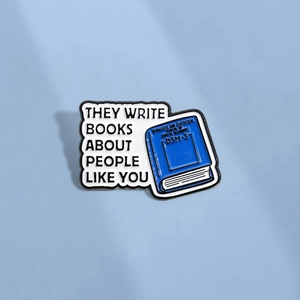 DSM-5 psychology book enamel pin with text bubble on a clean light blue background