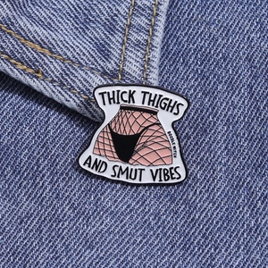 Détail d'un pin's en émail bas résille avec texte sur tissu denim bleu clair