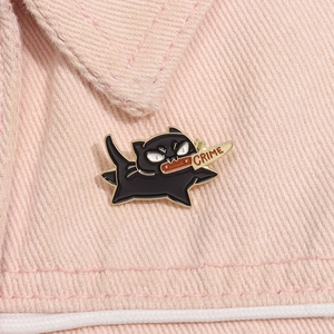 Détail d'un pin's chat noir en émail avec poignard CRIME sur col en jean rose