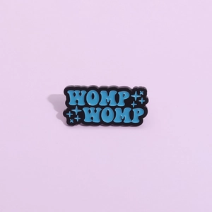 Spilla creativa in smalto blu WOMP WOMP con motivi a stella su sfondo viola chiaro