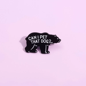 Black enamel bear pin with 'Can I pet that dog' text on a soft pink background