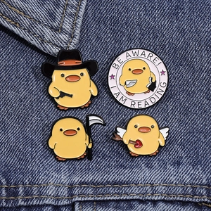 Lot de quatre pin's émaillés canards jaunes sur denim, avec motifs cowboy et ange