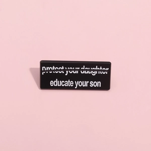 Gros plan d'un pin's rectangulaire en émail avec texte sur fond rose pastel