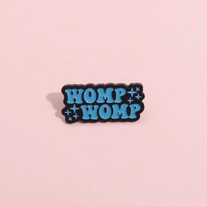 Spilla in smalto blu WOMP WOMP minimalista con stelle glitterate su sfondo rosa