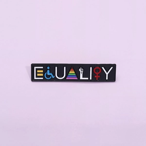 Macro shot of 'EQUALITY' rainbow enamel pin featuring human rights symbols on purple background