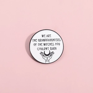 Creative women's power enamel pin with motivational quote on a soft pink background