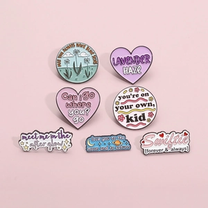 Set of 7 colorful enamel pins featuring Taylor Swift lyrics on a pink background