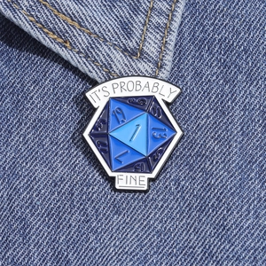 Detailed macro view of a D20 dice enamel pin on blue denim with text It's Probably Fine
