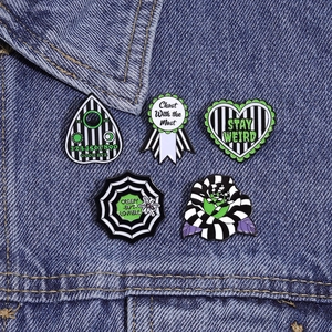 Gothic style green enamel lapel pins set pinned on a denim jacket for a creepy look